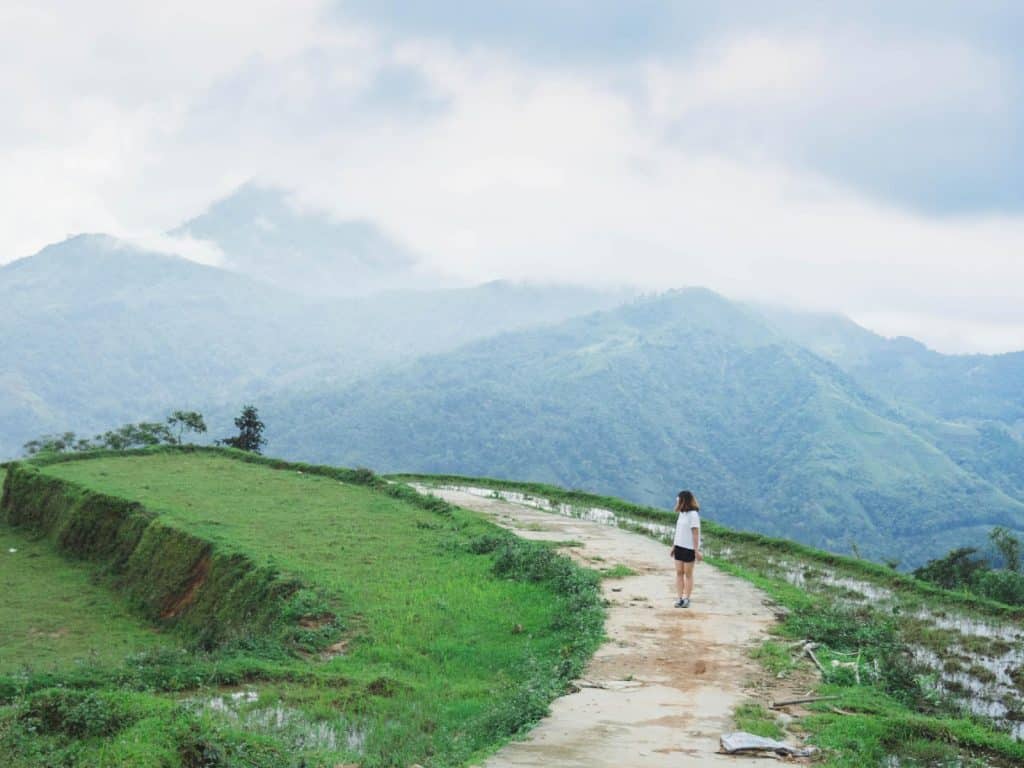 Girl walking along path looking back at mountains